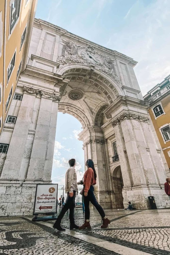 couple in front of Arco da rua Augusta in Lisbon