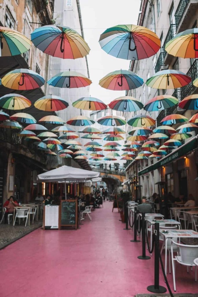 Pink street with umbrellas in Lisbon