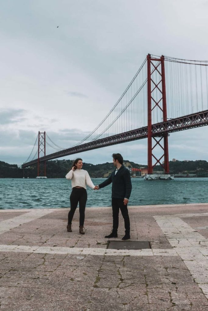 couple in front of Ponte 25 de Abril in Lisbon