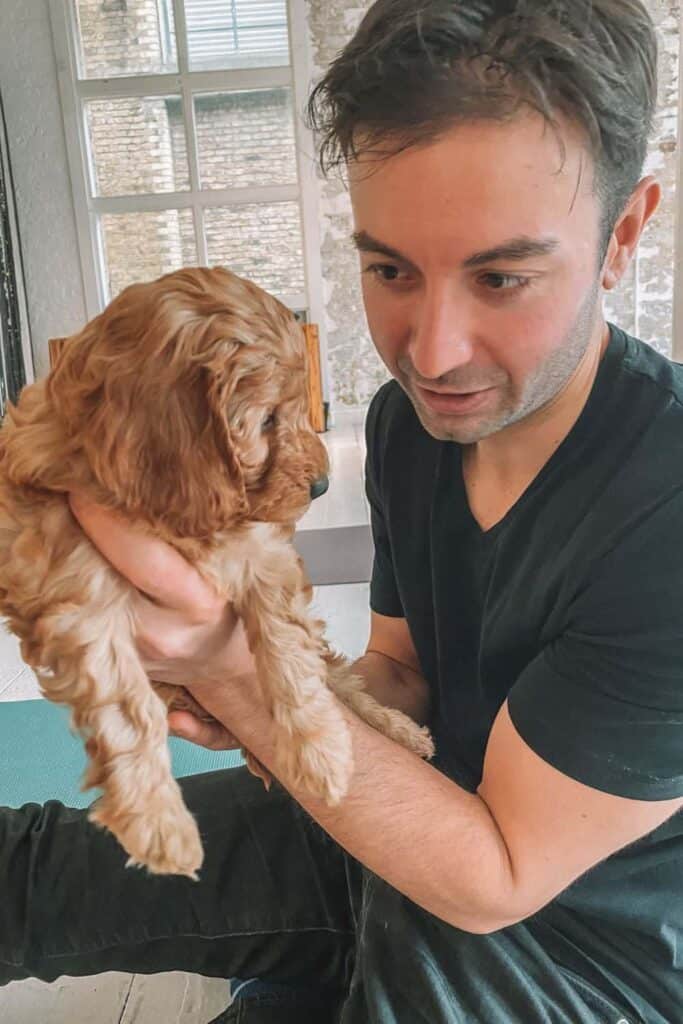 Eric holding a cockapoo at Puppy Yoga in London