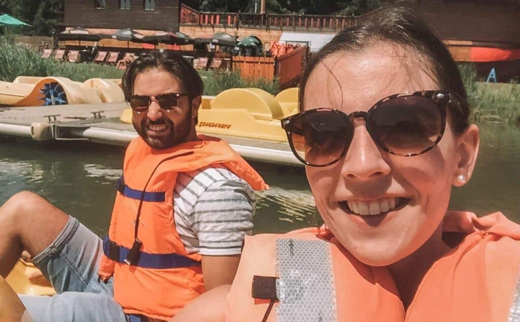 Us paddle boating near a lake beach in France