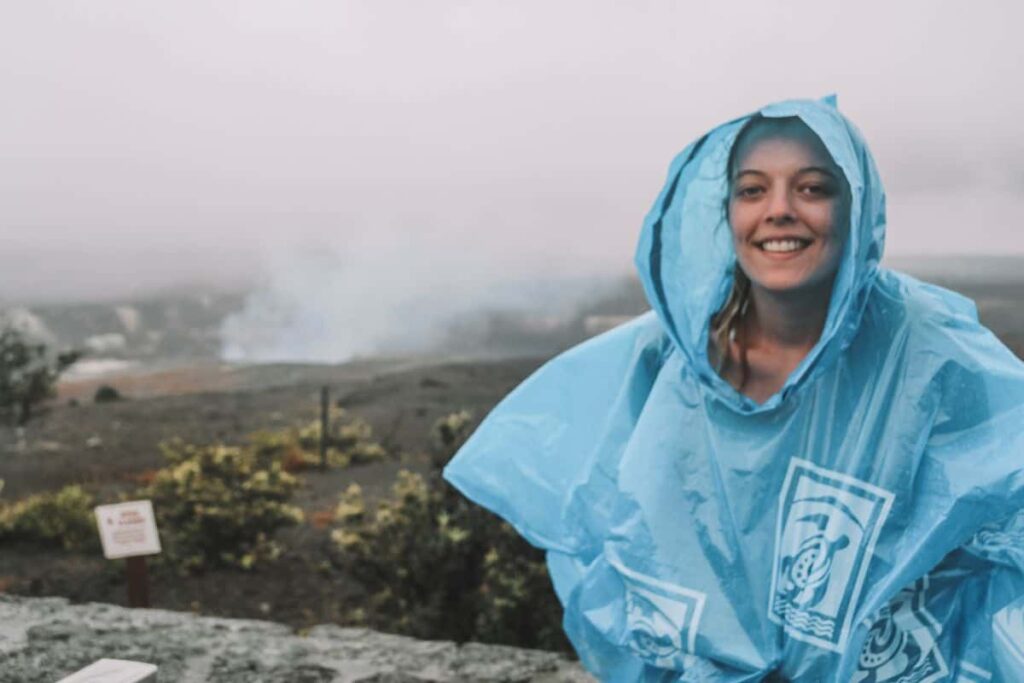 Marie wearing a poncho by the crater of the Hawaiian volcanoes