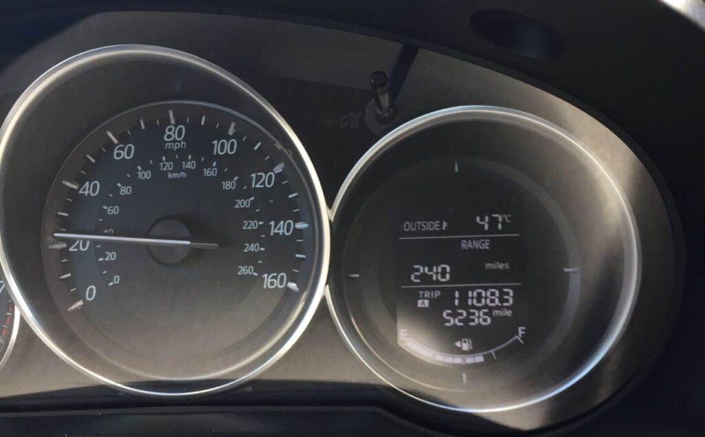 Our car dashboard indicating the leftover mileage with a full tank and the crazy temperature of 47 degree celsius