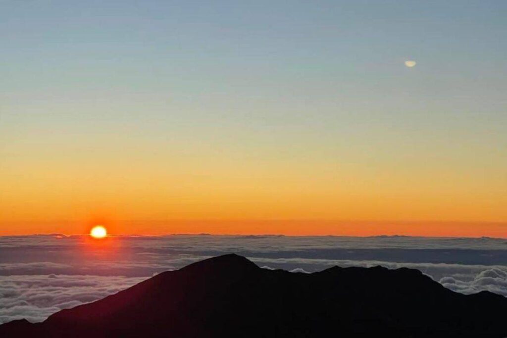 The sun setting in the horizon from Haleakala summit