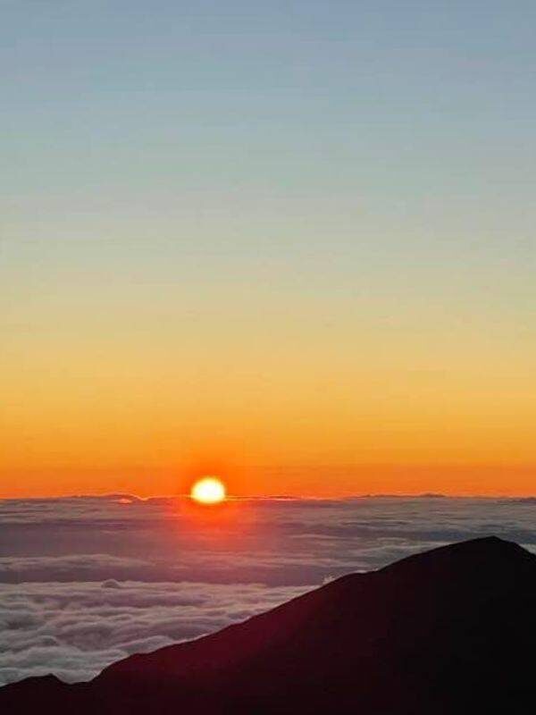 The sun setting in the horizon from Haleakala summit