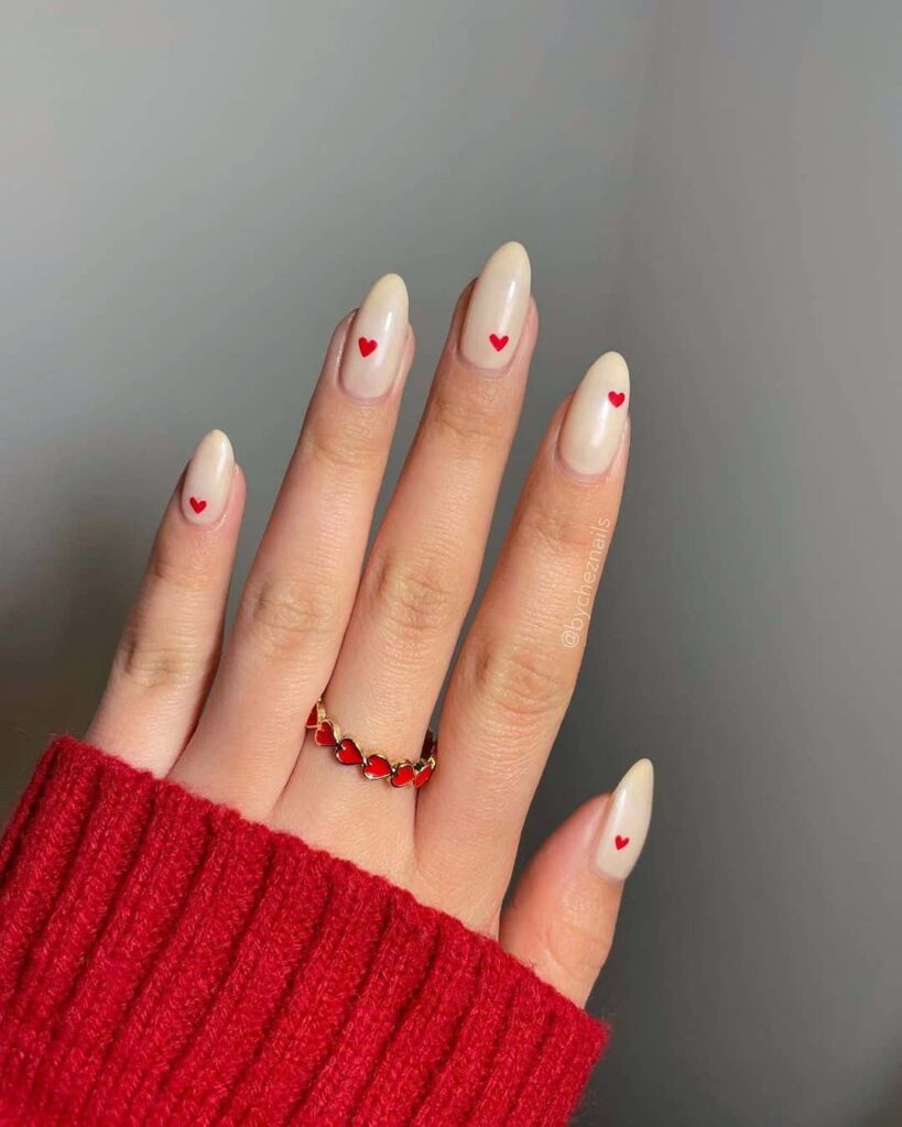 Red hearts on cream nails by @iluvmeae