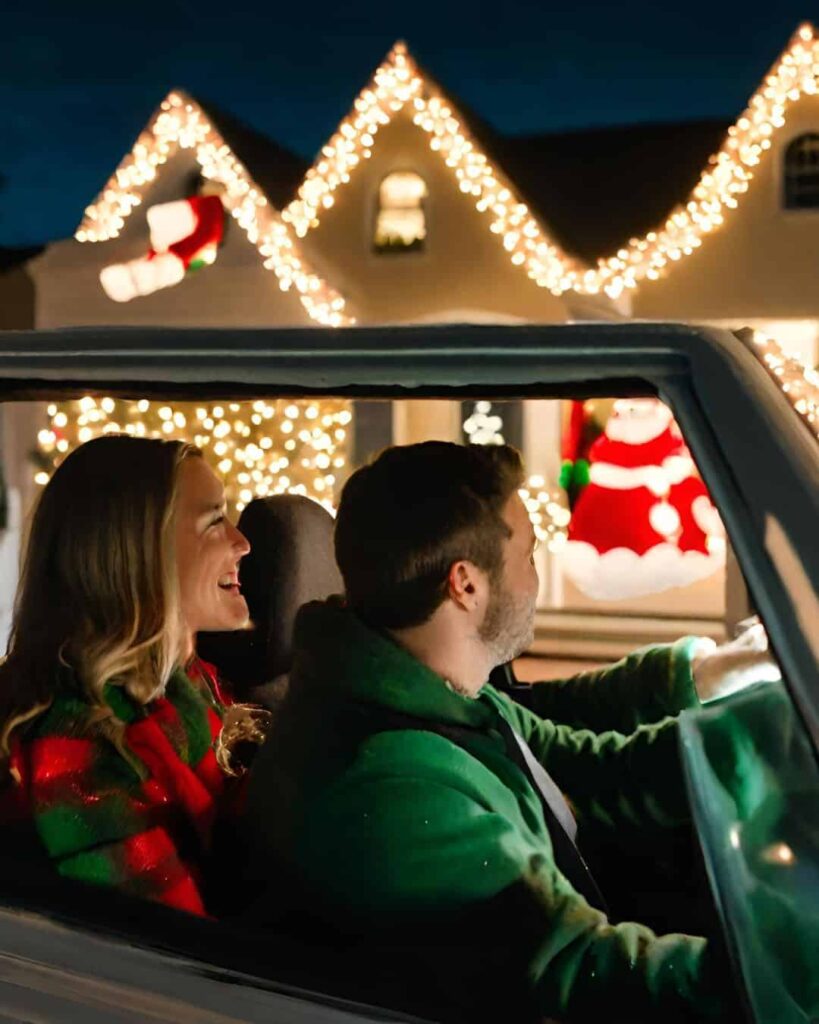 another couple driving by house decorated with Christmas lights