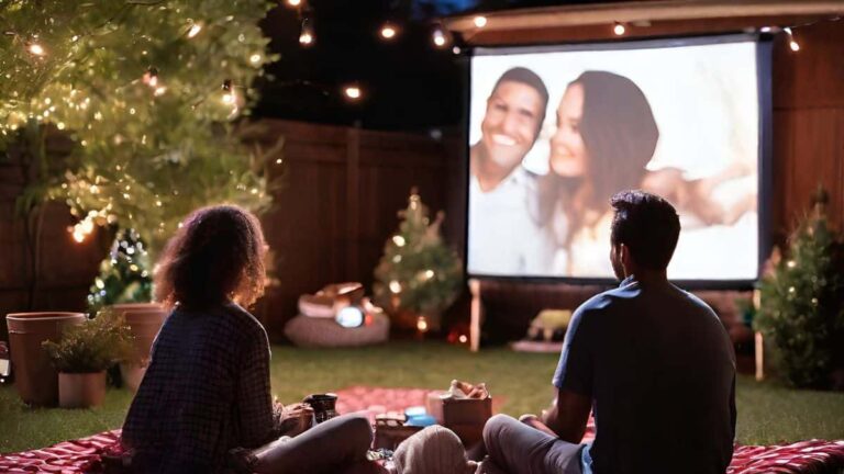 couple watching a movie in backyard with projector and twinkly lights together