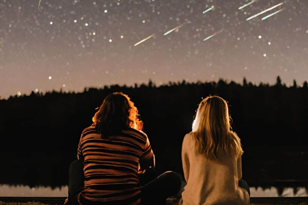 couple watching meteor shower in nature