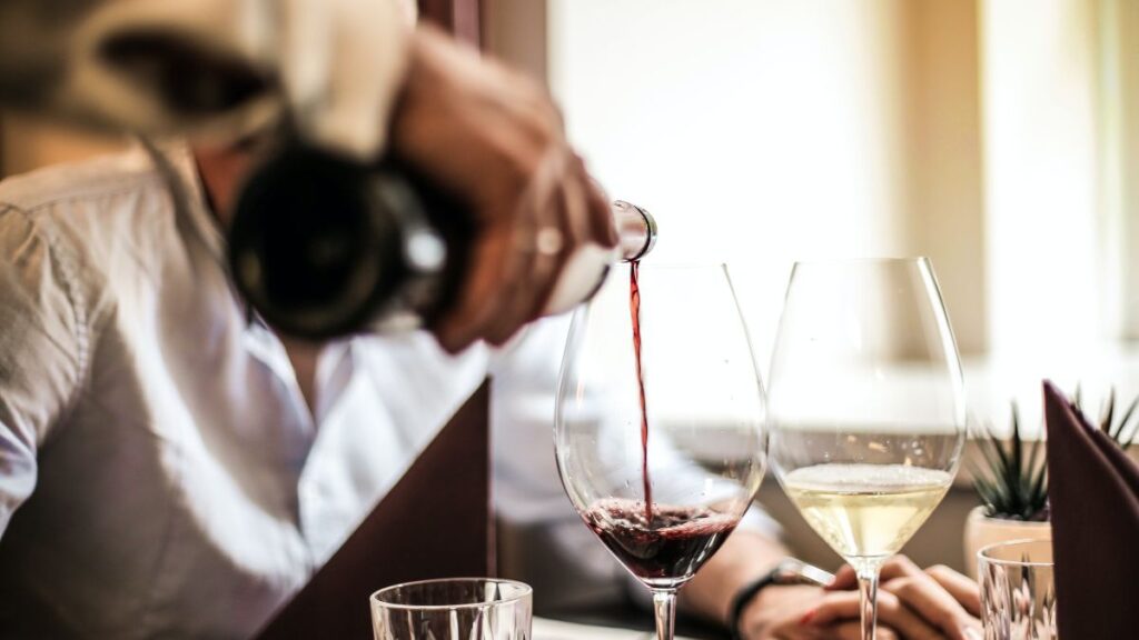 photo of hand pouring wine at restaurant
