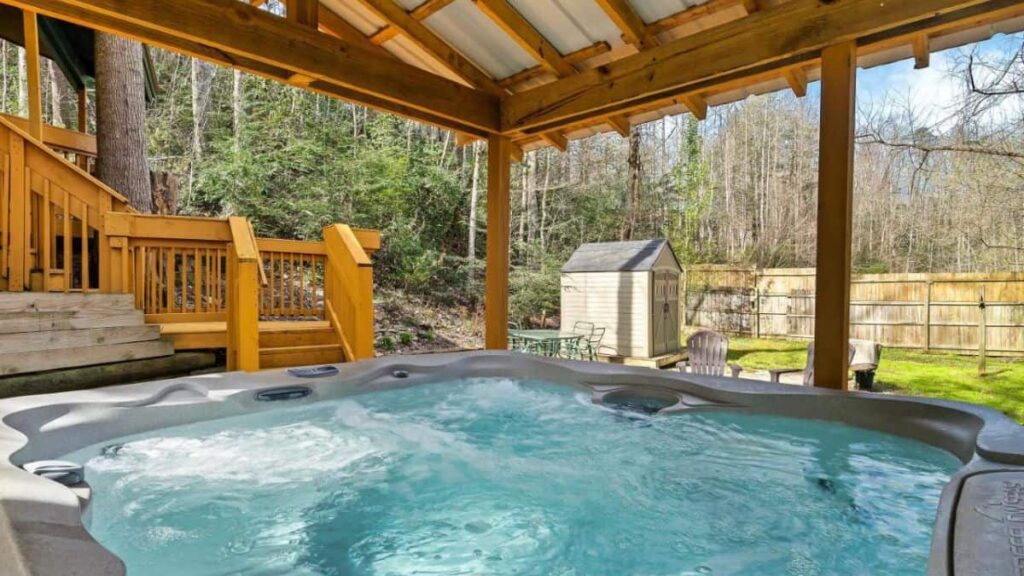 wooden cabin view with hot tub in the foreground
