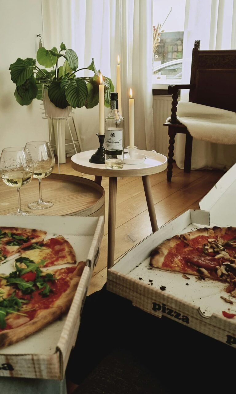 Two pizzas sitting on a table with a candle