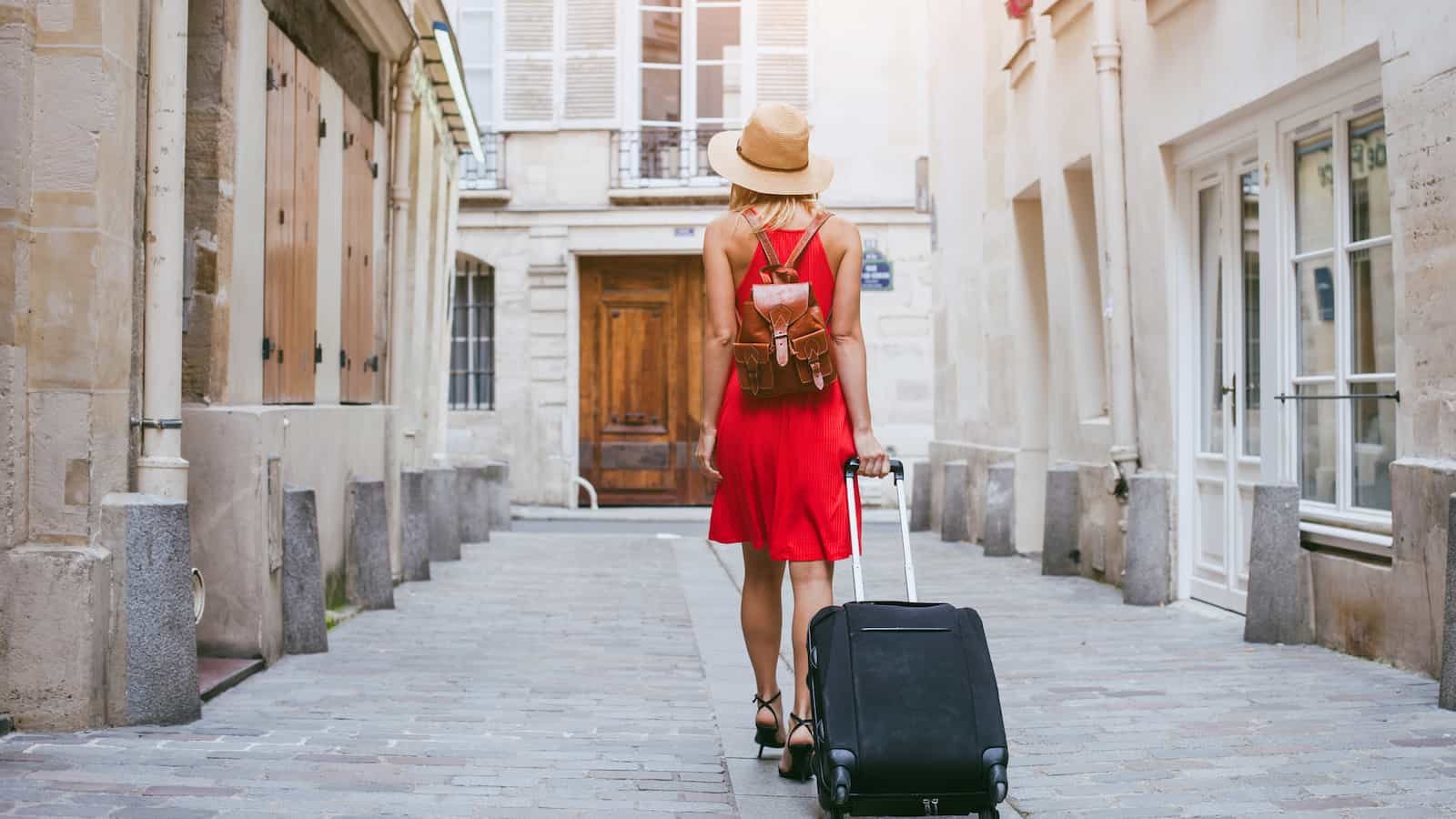 Girl going to hotel carry on suitcase packing europe european