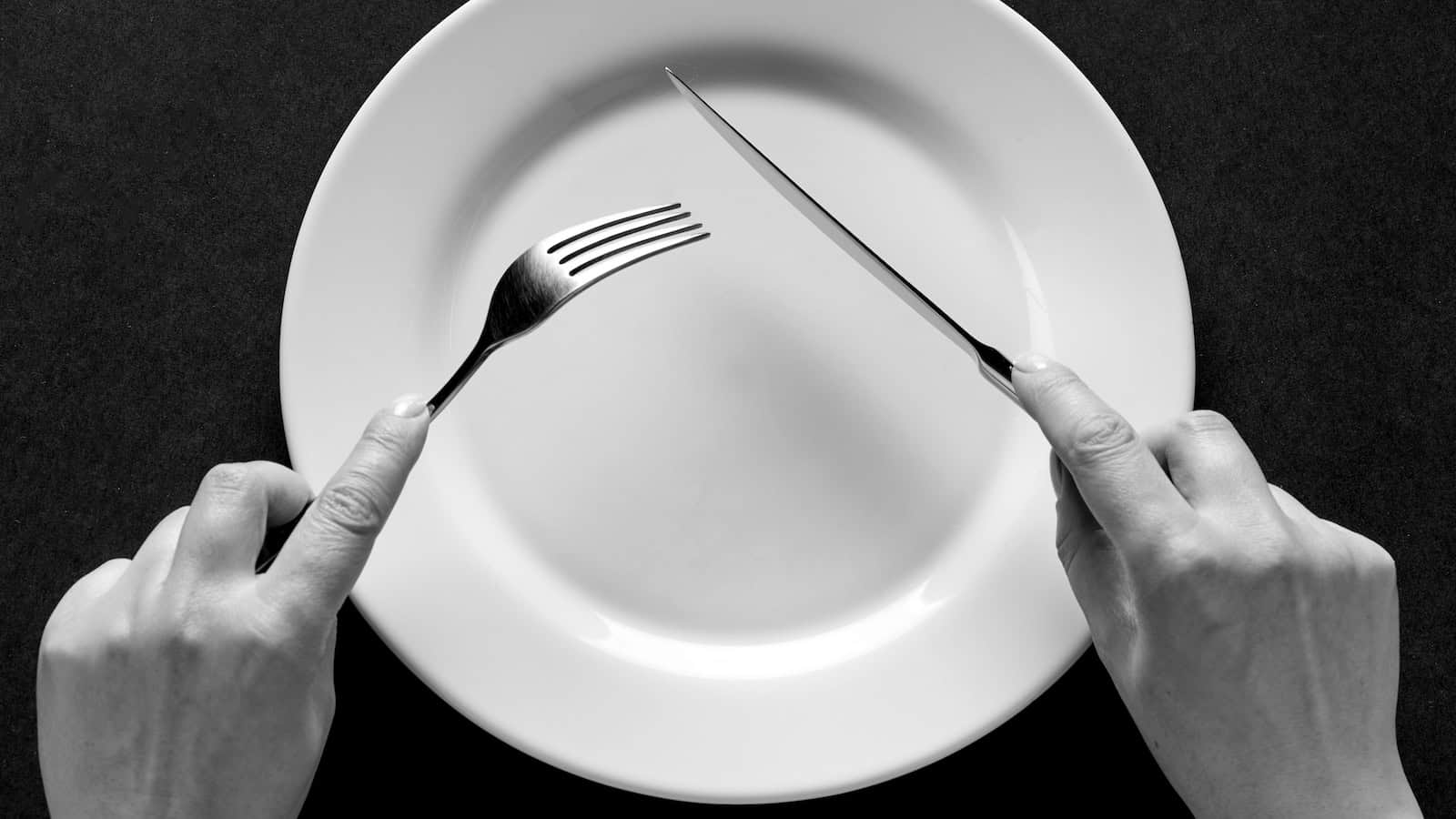 hands plate eating shutterstock_1613268565