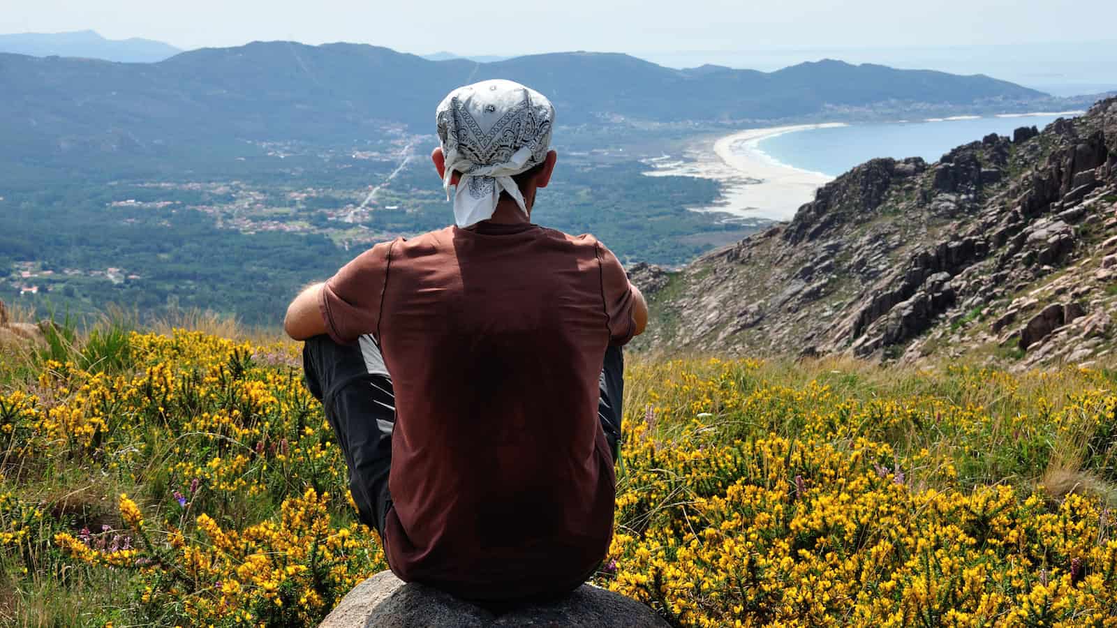 hiker mountain bandana rest tired looking at view shutterstock_1655453776
