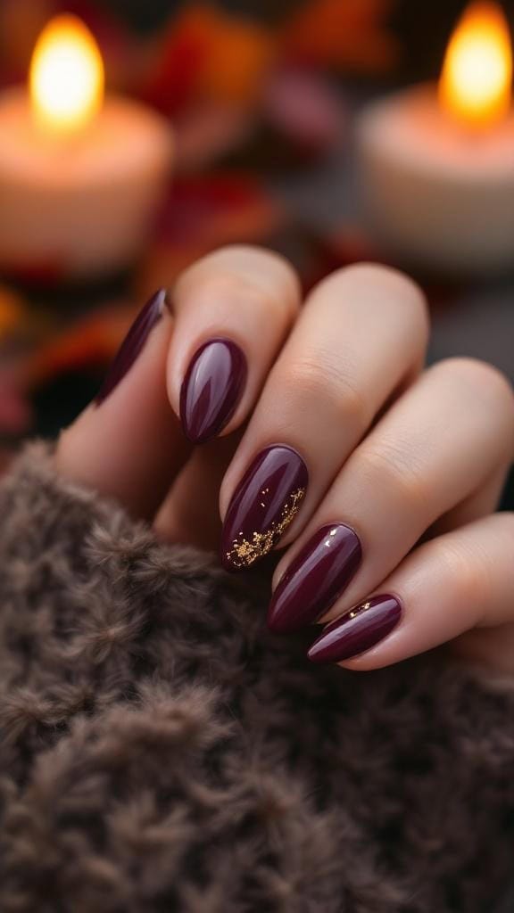 Deep plum glossy nails with gold flakes, set against a cozy background.