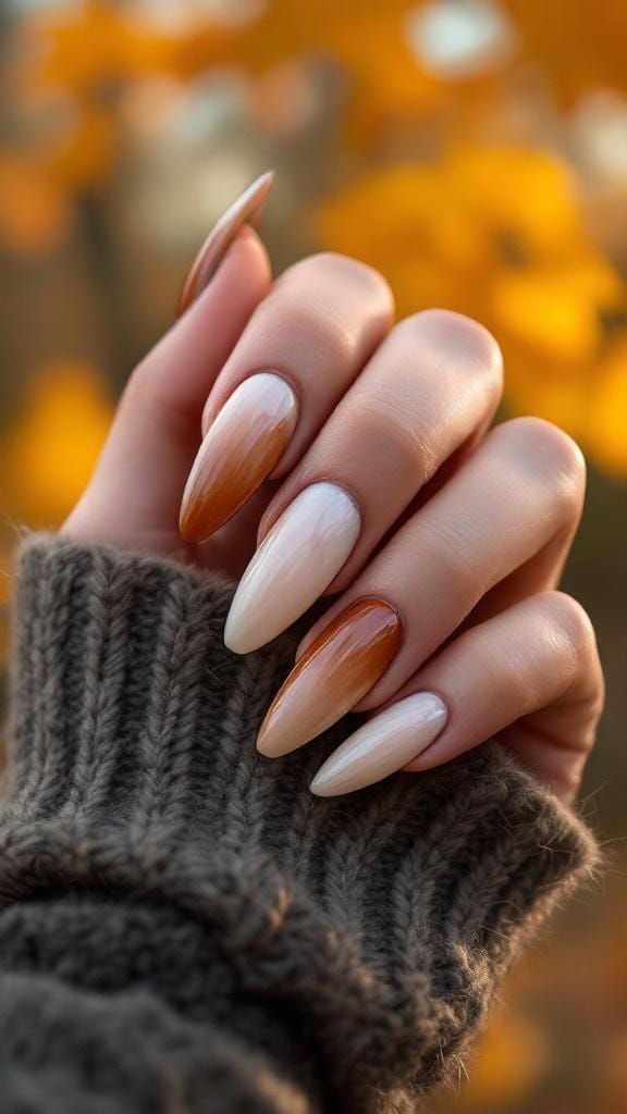 Chestnut and ivory marble fade nails on a hand with a knitted sweater
