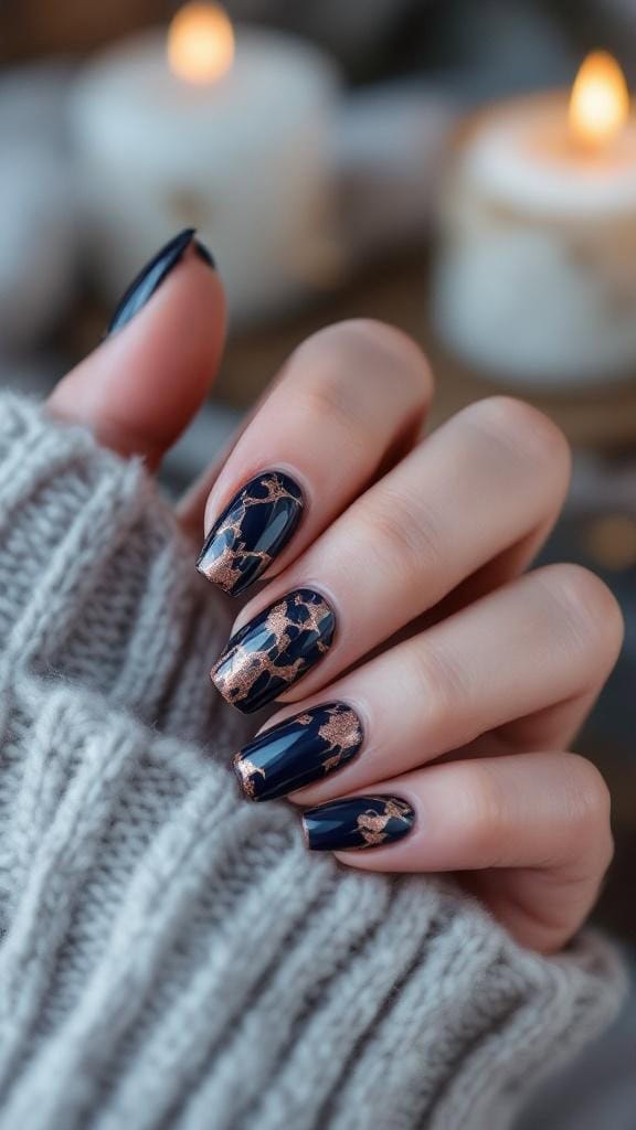 Navy and bronze marble fall nails with a cozy sweater background.