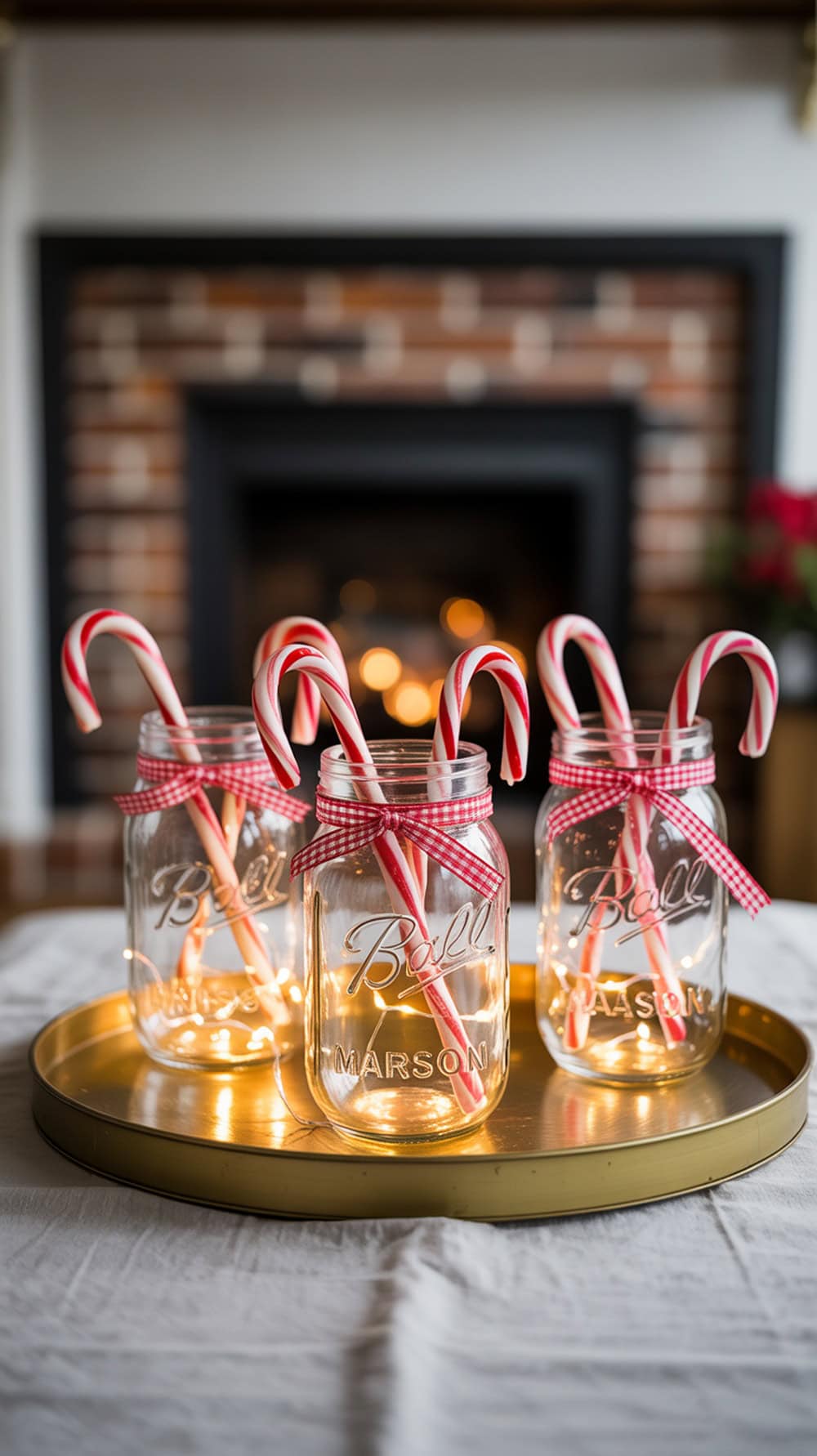 Mason jars with red ribbon and candy canes on a tray, decorated for Christmas.