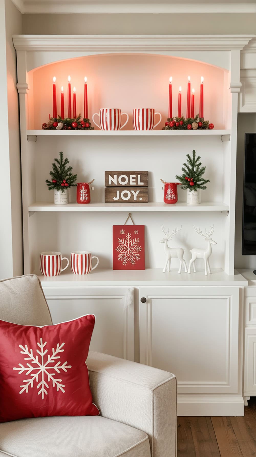 A modern farmhouse built-in shelf decorated for Christmas with red and white items, including striped mugs, candles, and greenery.