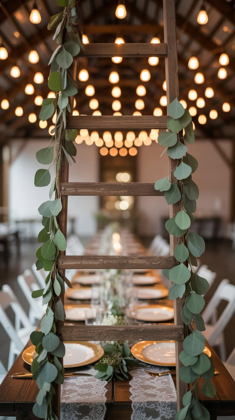 A wooden ladder decorated with greenery and string lights, set above a beautifully arranged wedding table.