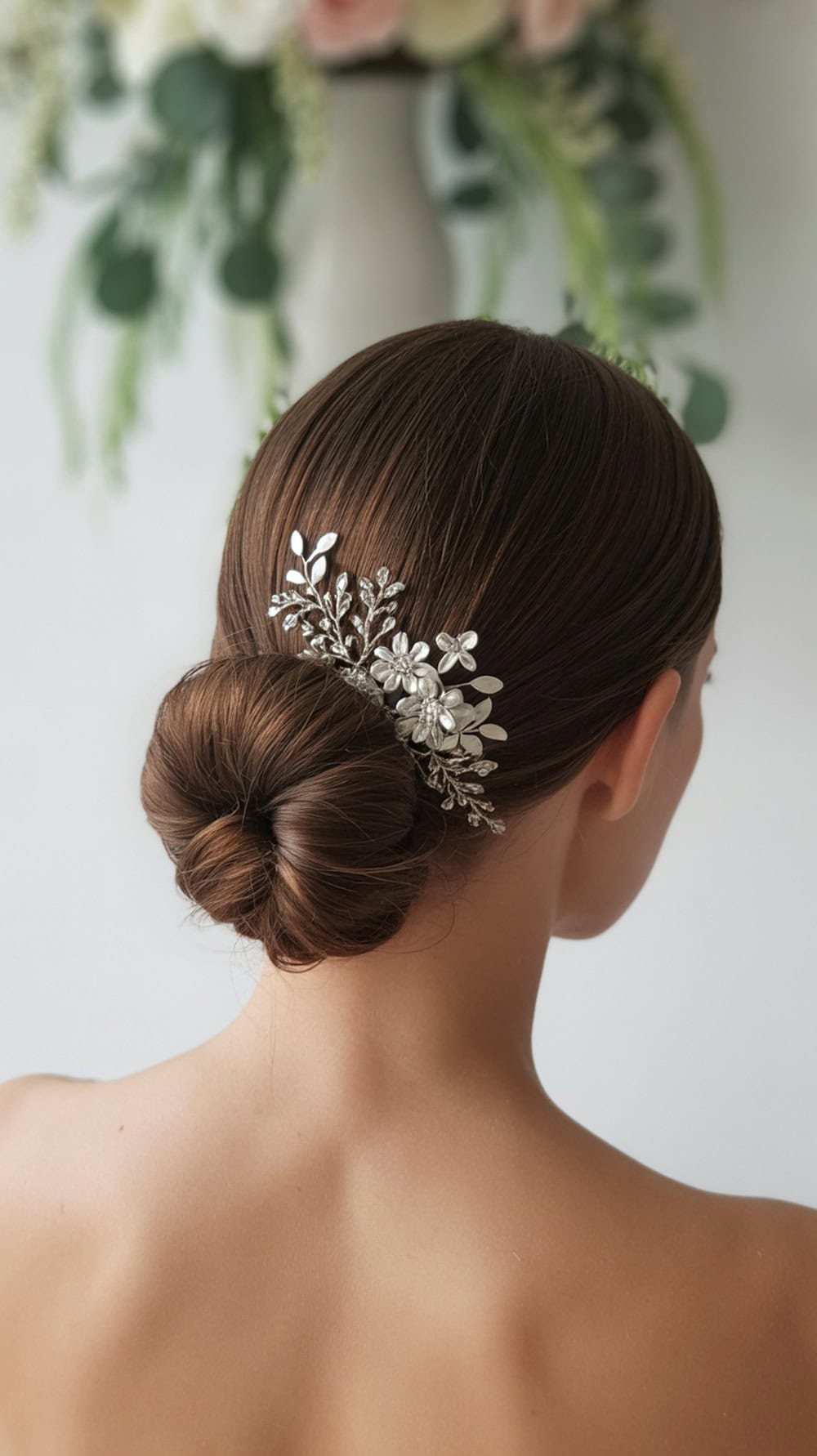 A classic sleek chignon hairstyle with a decorative hair comb, showcasing a polished look.