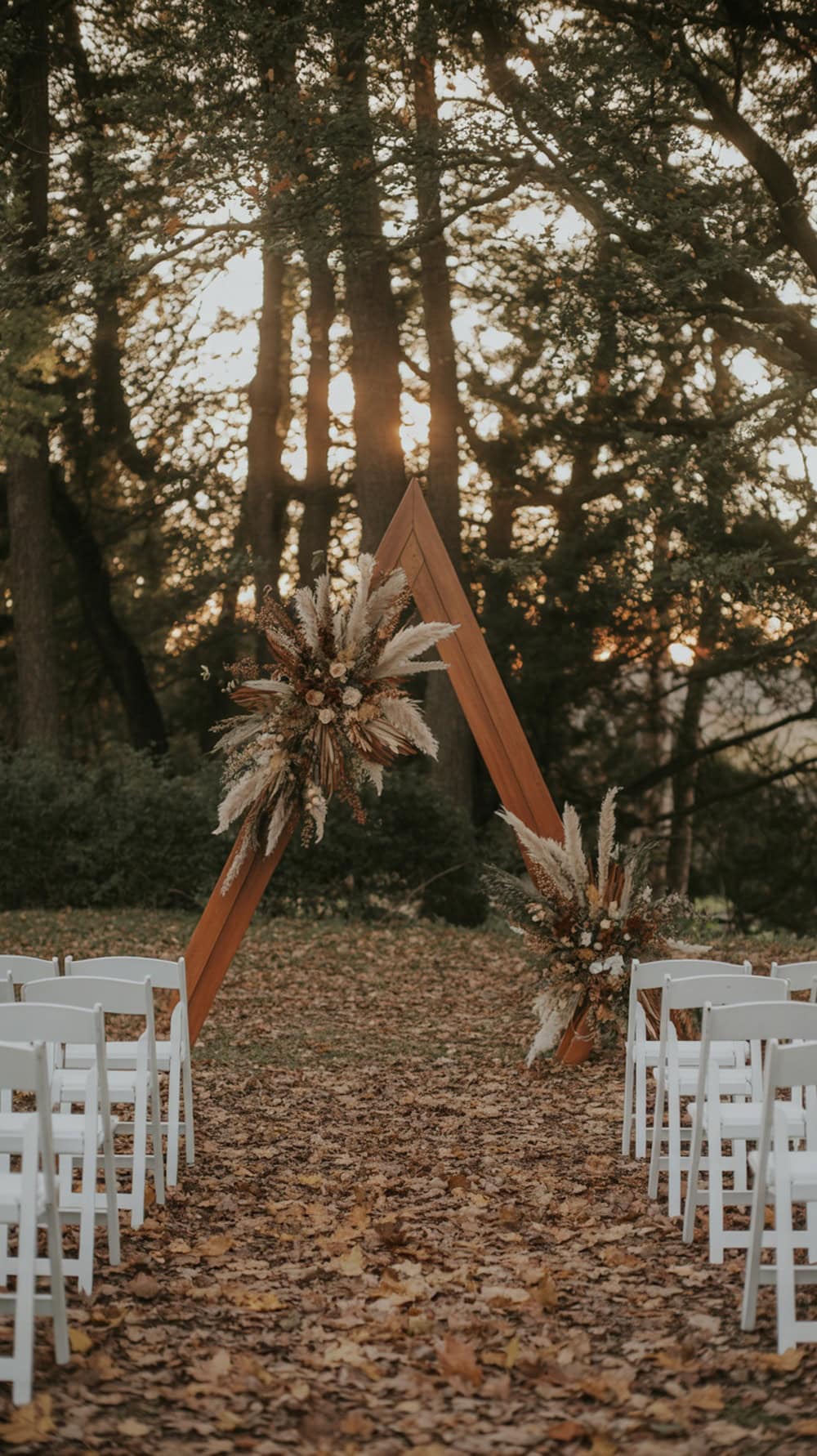 A forest clearing set up for a wedding ceremony with wooden altar and white chairs.