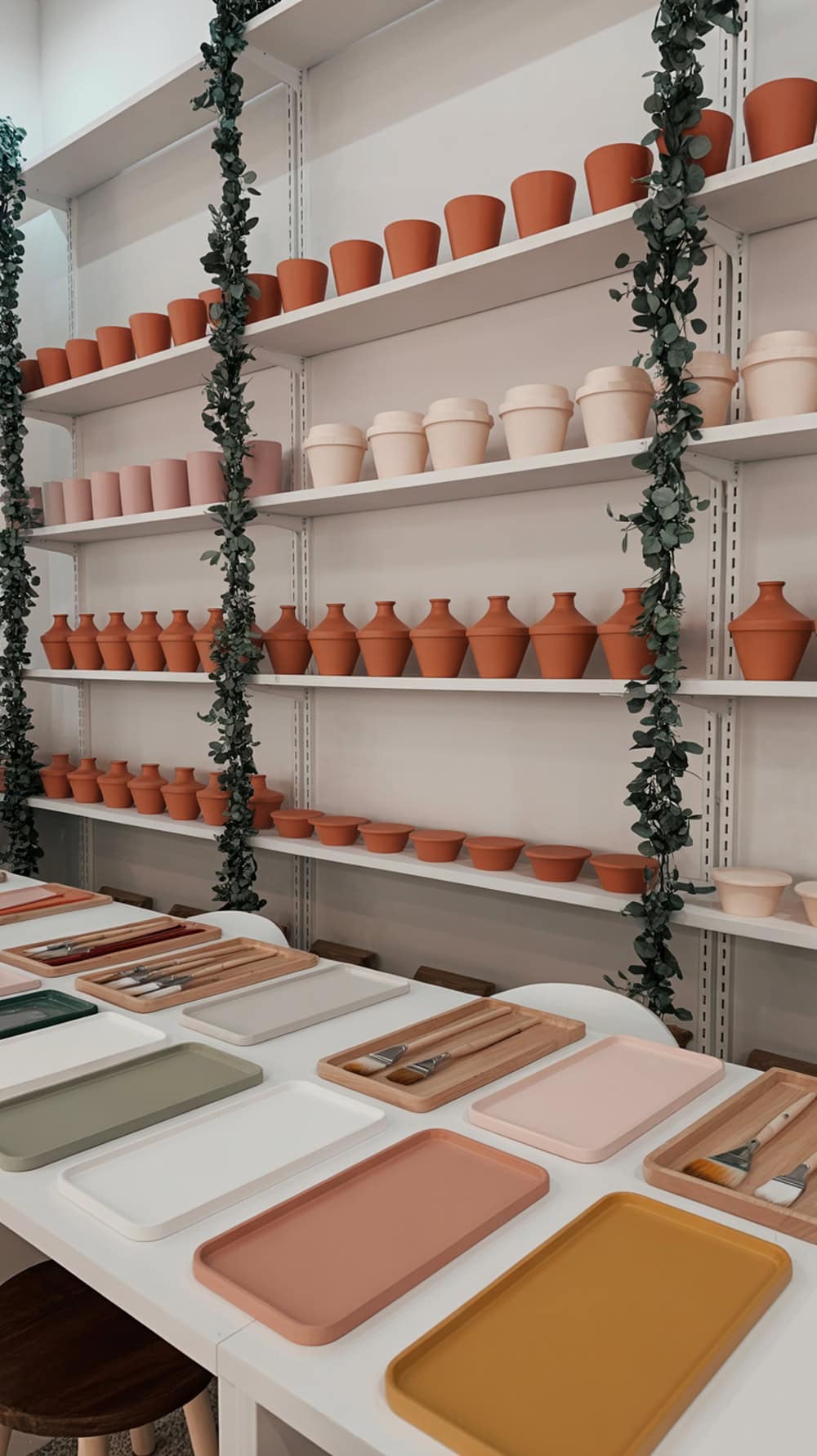 Indoor setup for a Paint-A-Pot activity with colorful pots and painting supplies.