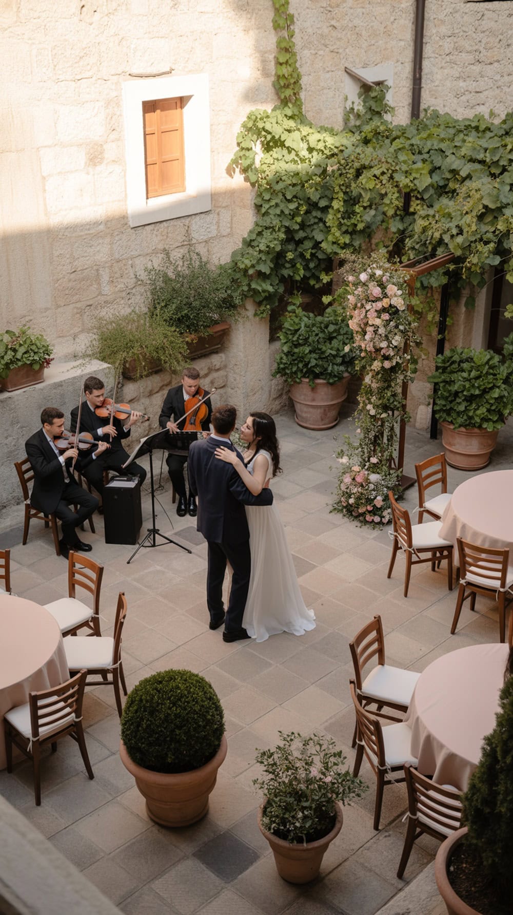 Couple dancing in a garden courtyard wedding with musicians and decorated tables