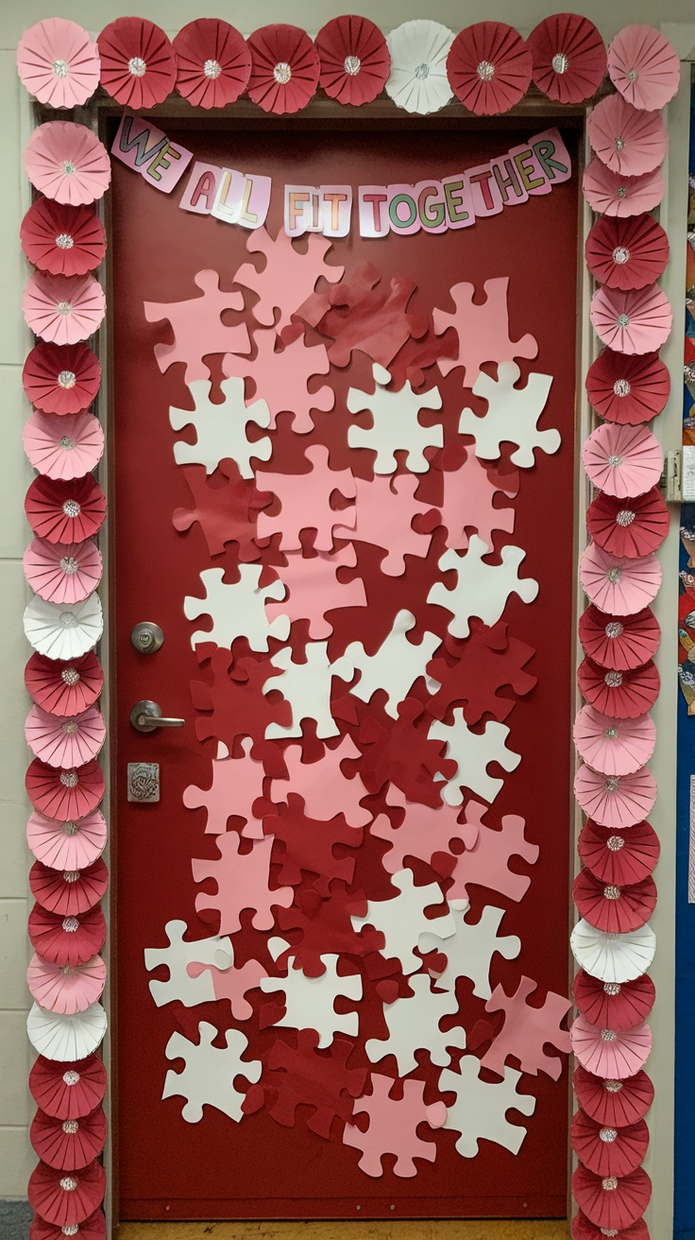 Classroom door decorated with puzzle pieces and flowers for Valentine's Day