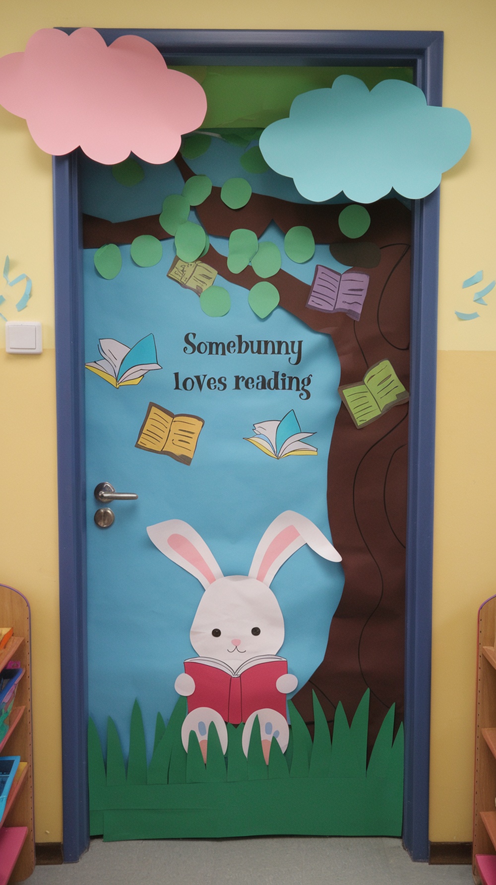 A classroom door decorated with a bunny reading a book, surrounded by trees and clouds, with the text 'Somebunny loves reading'.