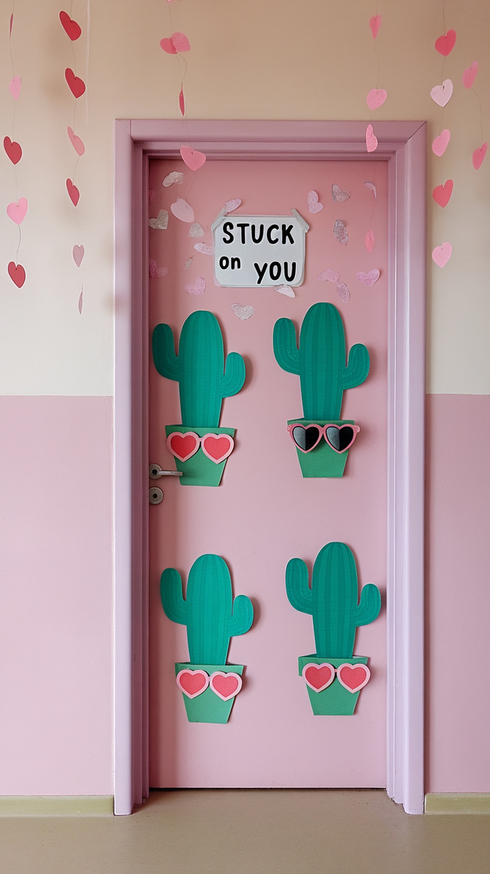 A classroom door decorated with cacti, heart-shaped pots, and a sign that says 'STUCK on YOU'.