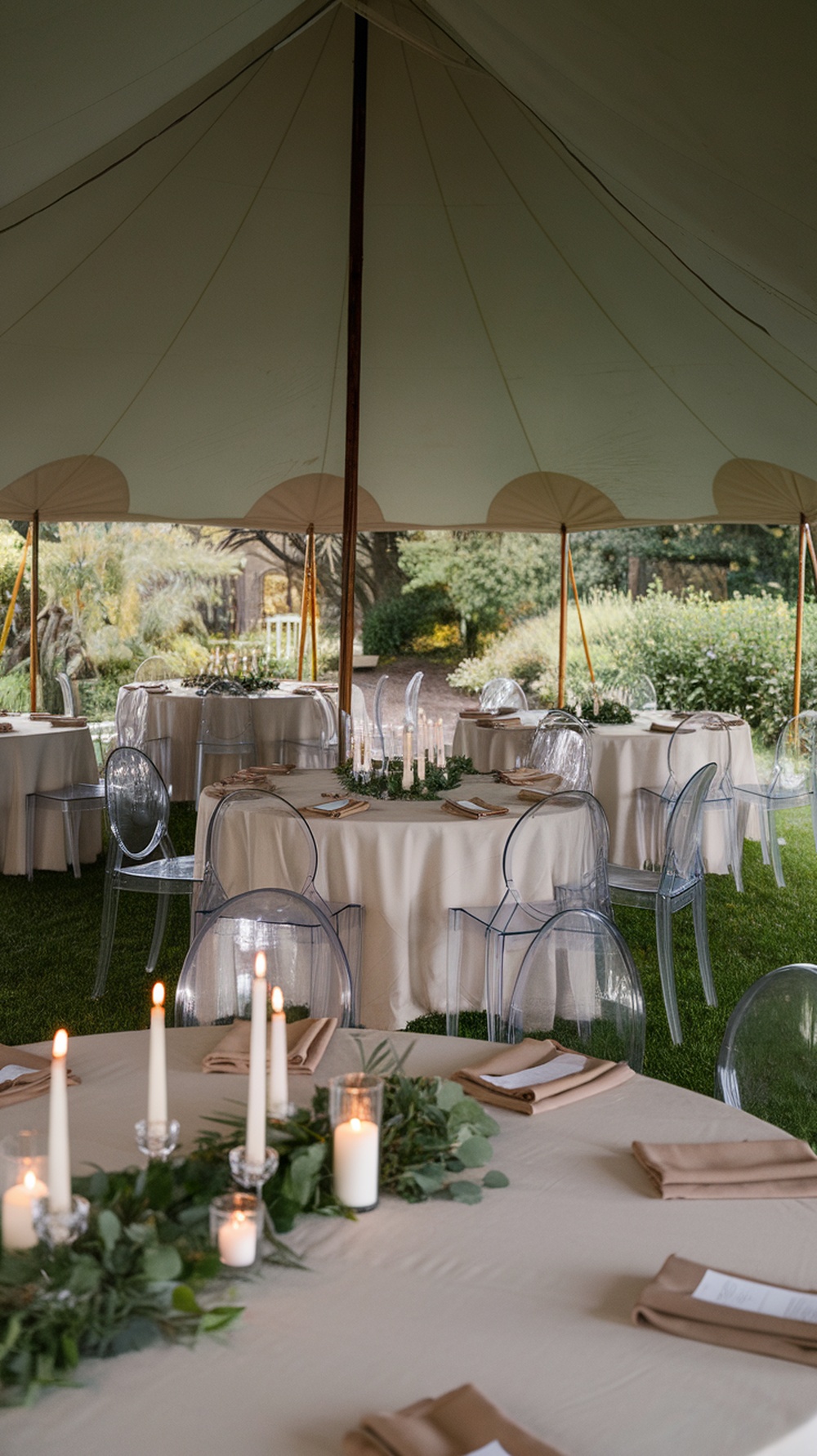 Tented outdoor dining area with elegant table settings and candles