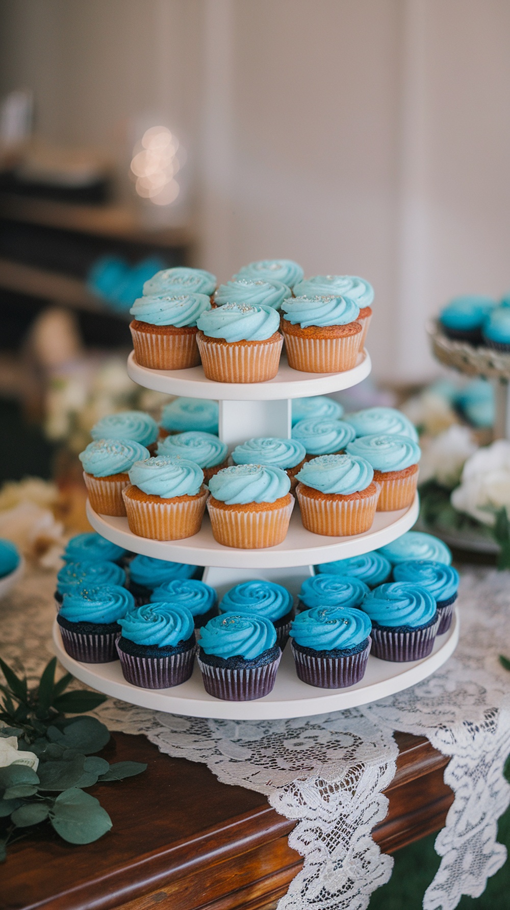 A tiered cupcake tower featuring blue ombre cupcakes in various shades of blue.