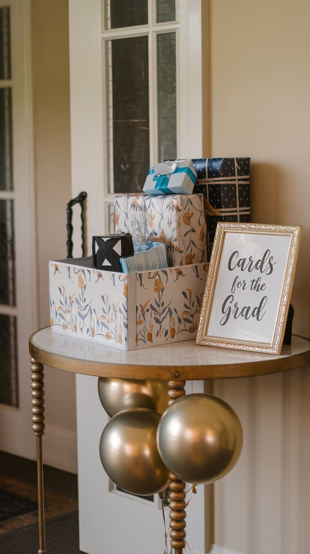 A decorated table with gifts and a sign for cards at a graduation party.