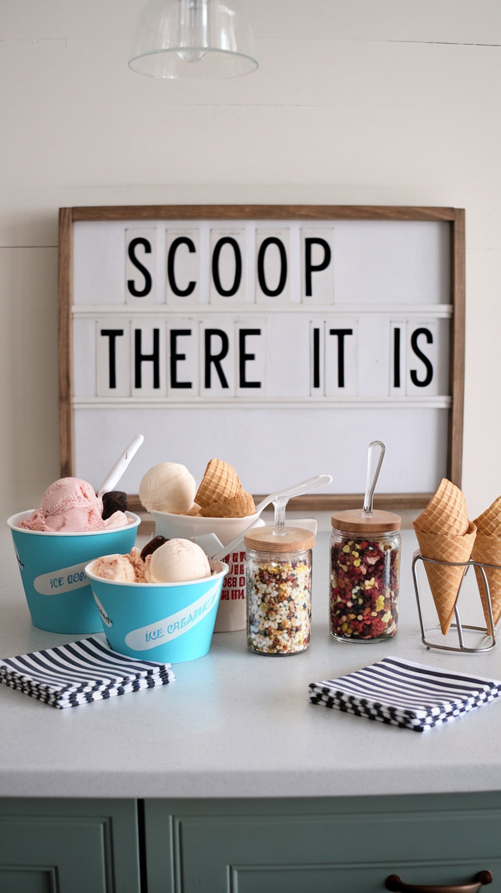 An ice cream sundae station with various flavors, toppings, and a playful sign.