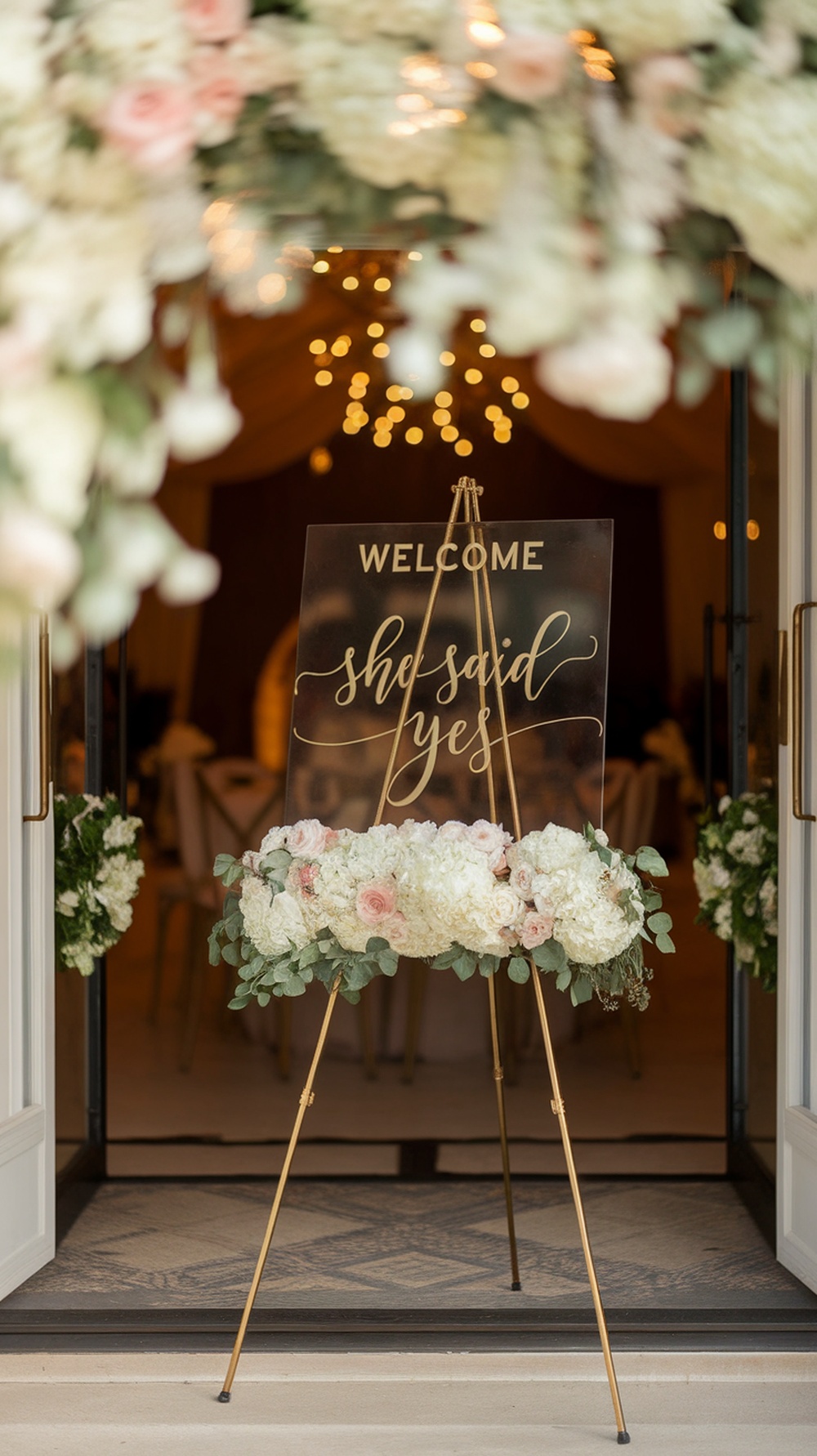 A bridal shower welcome sign with the text 'she said yes' surrounded by flowers.
